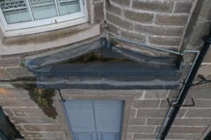Insufficient rainwater goods on a flat roof contribute to water damage