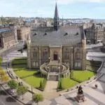 A grand stone building in gothic revival style with elaborate staircase.